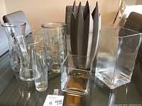 Nine vases of varying shapes and sizes arranged together on a table.