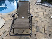 Full view of zero gravity lounge chair in upright position on patio near pool.
