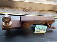 Rusty metal truck hitch receiver with 1-7/8 inch trailer ball attached, showing size and part numbers on ball top.