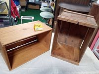 Two vintage wood boxes placed on a white surface, one upright showing stained interior, the other on its side showing slatted wood construction