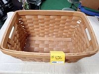 Overhead photo showing the inside and woven pattern of the large wicker basket with a yellow label