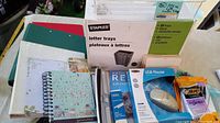 Photo showing letter trays box, binders, spiral notebook, USB mouse box, calendar, and pens