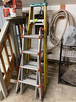 General view of both ladders stacked upright showing overall condition and included items