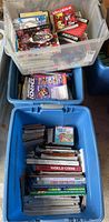 Three plastic bins filled with assorted video game magazines, books, and games