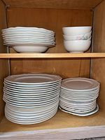 Top shelf showing stacked 8 pink floral soup bowls and 8 salad plates beneath