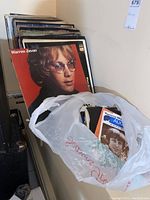 Stack of vinyl LP records leaning against wall, front cover Warren Zevon