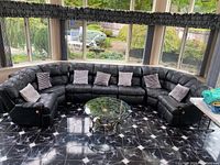 Wide shot of full black leather U-shaped sectional and coffee table