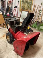 Overview of red Toro PowerThrow 824XL snowblower showing housing, chute, engine, handle, and tires