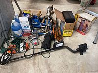 Full view of tools and equipment including metal detector, boxes, extension cords, cleaning liquids, and hand tools.