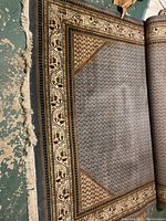 Partial view of full rug showing blue lattice field and cream geometric border with fringe