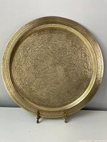 Front view of the round brass tray showing full circular engraved Islamic design and raised rim.