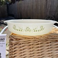 Side view of Glasbake milkglass baking dish showing green floral daisy and primrose pattern with flat sides and pouring spouts