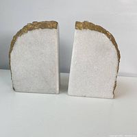 Front view of two quartz bookends with white crystal surfaces and gold-colored rough edges, placed side by side.