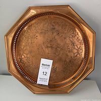 Front view of the vintage copper octagonal gallery tray showing etched floral patterns and tarnishing.