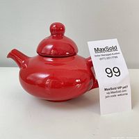 Red ceramic teapot with lid and rounded shape, 4.5 inches tall