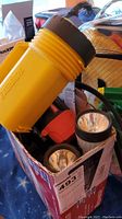 Box containing multiple flashlights including large yellow Eveready flashlight and smaller lights.