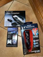 Three boxed groomers: Philips Norelco T980, Panasonic personal hair trimmer, and Sharper Image Ultra Groomer with comb accessories.