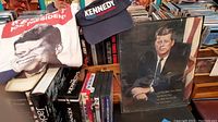 Photo showing JFK T-shirt, cap, books, DVDs, and framed photo
