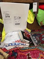 Photo shows one white Kennedy-themed T-shirt folded with visible red and blue print.