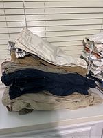 Stack of men's shorts in various colors and styles including cargo and cotton, size 38/40 indicated on label.