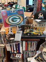 Overview of all items in the lot, showing trailer hitch cover, signed helmet, model roadster, banner in background