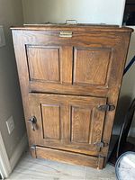 Front view of closed wooden icebox refrigerator