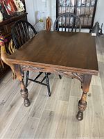 View of the antique wooden table showing top surface with slight distortion in wood grain due to stain.