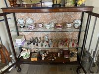 Full view of cabinet with glass doors open showing interior shelves