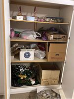Photo of shelves with bags, boxes, and baskets containing various Easter and holiday decorations including plastic eggs and China box.