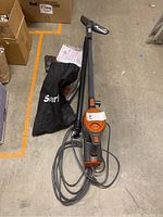 Full view of Shark Rocket vacuum cleaner assembled with power cord and accessory bag on floor.