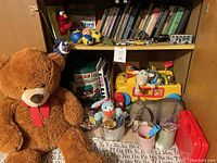Shelf with vintage children's books and small toys including stuffed animals, toy vehicles, Lincoln Logs container