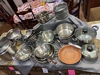 Full assortment of pots and pans arranged on kitchen counter showing various sizes and finishes