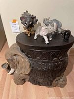 Full view of elephant carved stool with four elephant figurines on top, showing overall condition and arrangement.