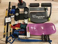 Overview of the assorted exercise equipment laid out on floor including Smart Wonder Core, FitGlide, resistance bands, Simply Fit Board, and Body Blades.