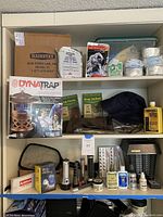 Shelf showing box of Mainstay SOS Food Lab emergency rations, DynaTrap Insect Trap brand new, bug pants and jacket packaged, alongside emergency supplies and insect repellent bottles
