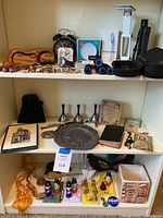 Photo showing top shelf with watches, alarm clocks, UV sanitizing wand, Dodow sleep aid, Swiss+Trxh tools, flashlights, Swiss army tools