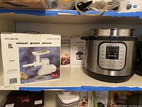 Instant Pot, Miracle wheat grass juicer in original box, accessories and manuals in background