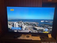 Front view of TV powered on displaying news channel