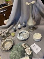 Full lot showing pewter and marble items including tall pewter pitcher, salt and pepper shakers, ashtrays, cheese board, coasters, and decorative eggs.