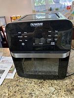 Front view of NUWAVE Brio air fryer oven showing digital control panel and glass door.