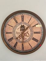 Front of wooden clock showing Foire de Paris 1919 design with Roman numerals and aged finish.