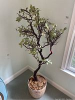 Overall view of faux tree showing branches, leaves, and planter from front angle.