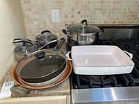 Overview of all pots and pans including the ceramic baking dish on a kitchen counter.