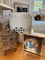 Photo showing the white ceramic garden stool, monkey themed decorative box with bronze monkey figurine, and the personalized clock with metal frame and black face.