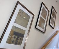 Three framed abstract wall art prints mounted on a white wall, each with textured designs featuring geometric shapes and linear patterns in neutral colors.