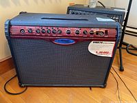 Front view of Line 6 Spider 210 amplifier showing black grille and red control panel with numerous knobs and inputs.