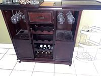 Front view of bar cart showing one drawer, two cabinets and bottle/glass storage