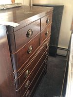 Front angle view of vintage 6-drawer dresser showing brass ring pull handles and wood finish with signs of wear.