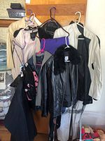 Overall view of jackets and ski pants hanging on a wooden board.