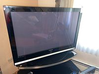 Full view of Samsung 42 inch flat screen TV on stand, showing black bezel and silver trim below screen.